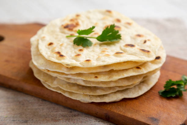 istock Homemade Roti Chapati Flatbread on a rustic wooden board, side view. Close-up. 1329247355