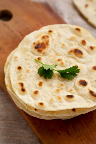 istock Homemade Roti Chapati Flatbread on a rustic wooden board, side view. Close-up. 1329247436