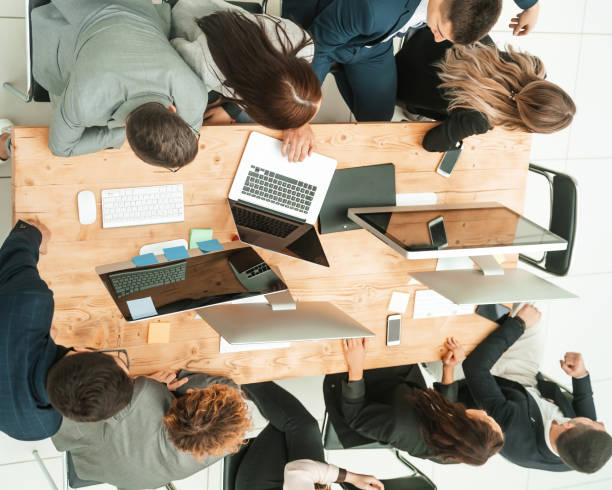 istock top view. business team sitting at Desk and looking at blank screen 1329257021