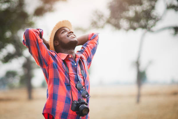 African Traveler man or photographers standing and traveling in the savannah fields stock photo