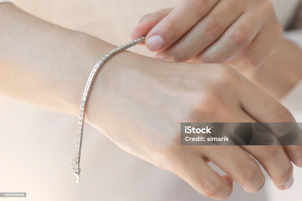 Diamond Bracelet Unrecognizable female is holding a diamond bracelet on her wrist. Bracelet Stock Photo
