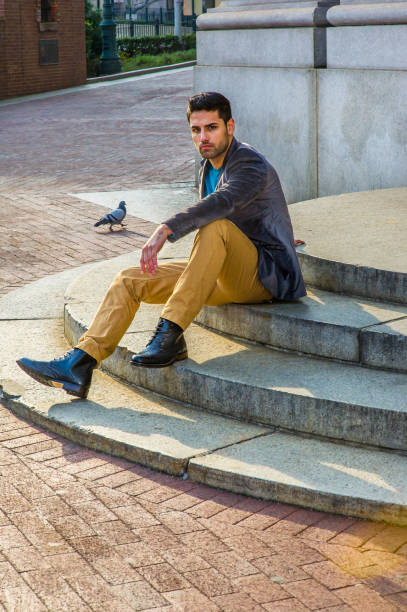 istock Young Man sitting on stairs outdoors, relaxing, thinking 1329260602