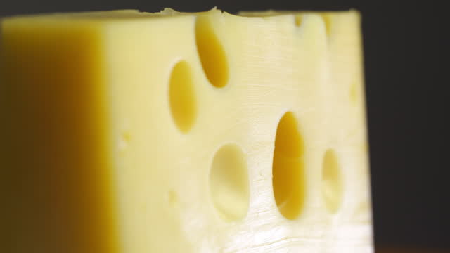 Swiss Cheese with holes close up, cheese rotates in slow motion background video