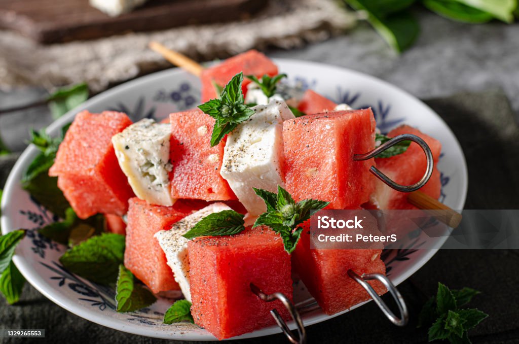 Delicious spicy skewers with watermelon Fresh melon with feta and blue cheese, topped with herbs Watermelon Stock Photo