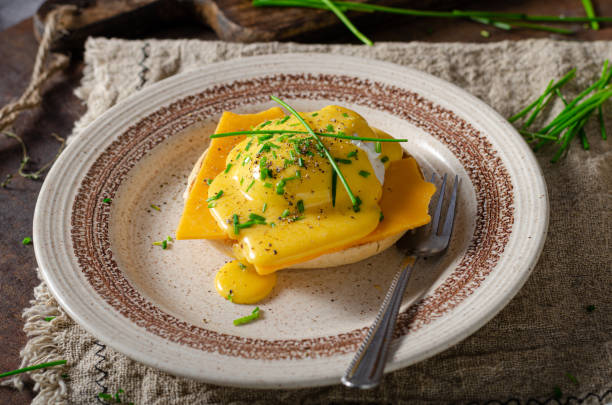 Delicious eggs benedict Organcic eggs benedict with bacon, cheddar cheese and herbs and hollandaise sauce hollandaise sauce stock pictures, royalty-free photos & images