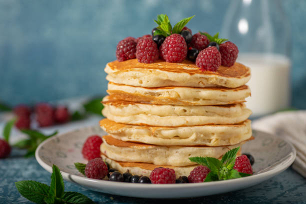 Fluffy american pancakes Delicious fluffy pancakes with berries and maple syrup food styling stock pictures, royalty-free photos & images