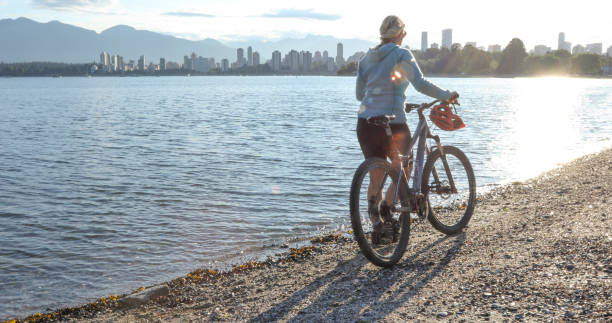 istock Female mountain biker relaxes on city beach 1329270837