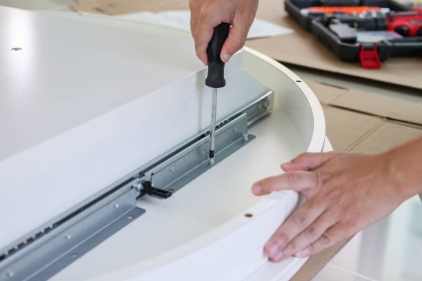 istock Asian man assembling white table furniture at home 1329276969