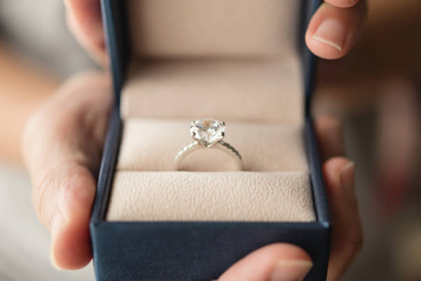 istock hands holding diamond ring in jewelry box 1329277243