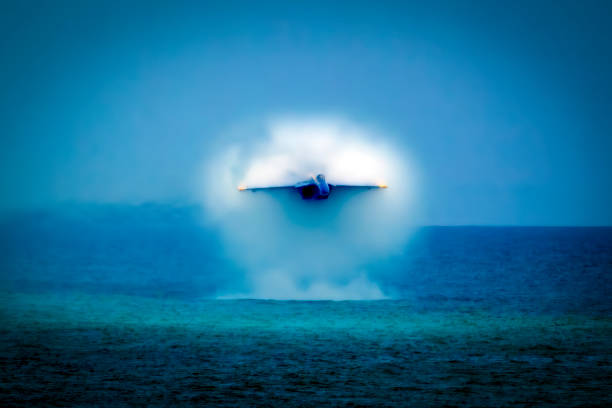 Blue Angel Solo Pilot Demonstrates High Speed Pass United States Navy Flight Demonstration Squadron Blue Angel demonstrates a high speed pass going transonic (almost Mach 1) over the Gulf of Mexico, Pensacola Beach, Florida airshow. us navy photos stock pictures, royalty-free photos & images