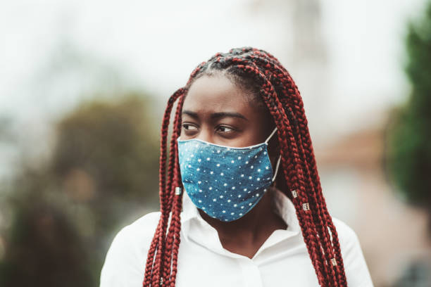 istock Black girl in virus-protective mask 1329282812