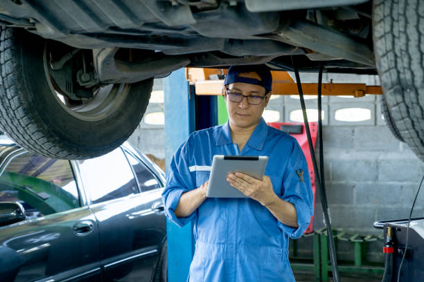 istock Asian automotive technician hold tablet and check data under car in mechanic shop 1329295300