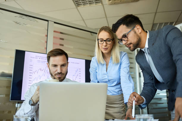 istock Business people developing winning strategies together in the office using laptop 1329296463
