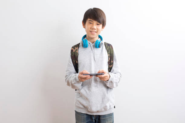 istock Asian teen boy student using smartphone isolate on white background. 1329301605