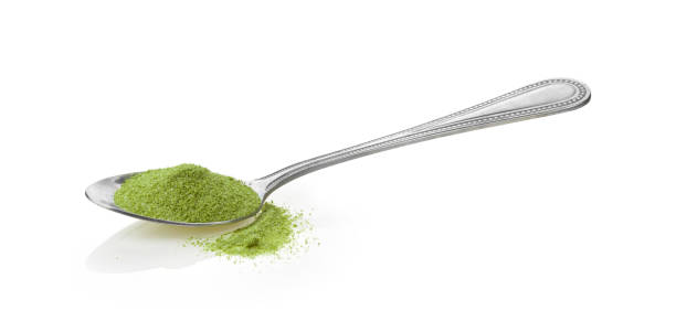 istock Instant green tea powder in spoon on white background 1329302925
