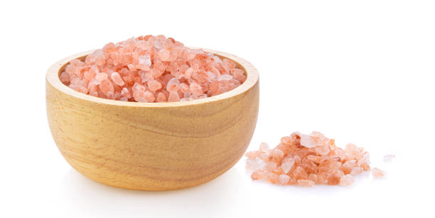 istock Himalayan salt raw crystals in wood bowl Isolated on white 1329302979