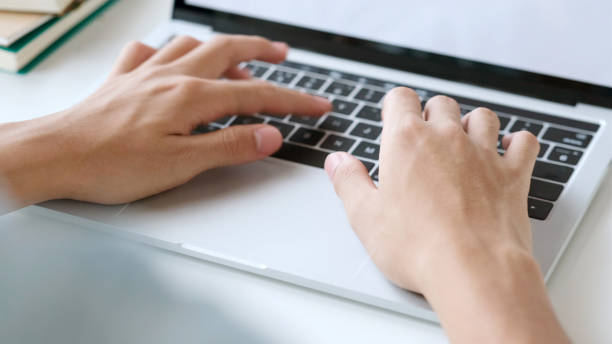istock Close up of man hand typing laptop computer while working at home office, Student college online study, learning, people and technology 1329303296