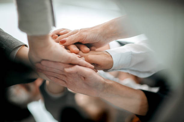 istock close up. a stack of hands. the concept of unity 1329307526