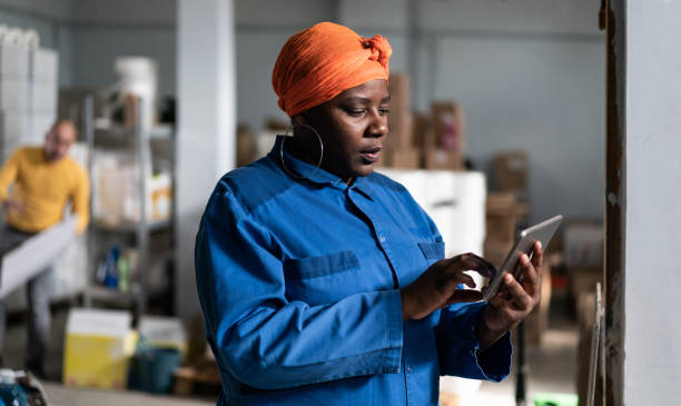 istock Afro female warehouse owner checking the shipment delivery on a digital tablet in distribution warehouse 1329307847