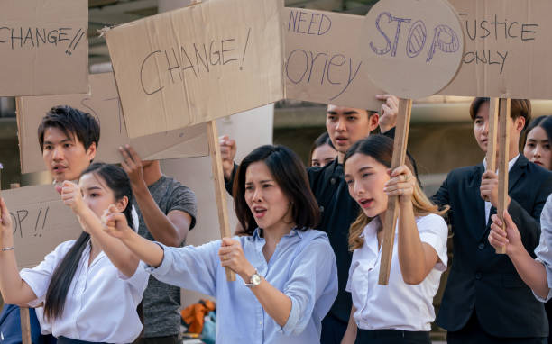 istock Group of protesters holding signs to protect for labour right 1329308475