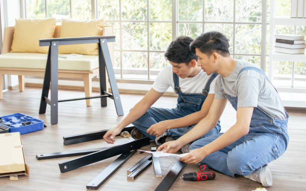 istock Two Asian handsome men wearing blue overalls, helping or supporting each other to assemble make DIY furniture following manual at home. 1329308866