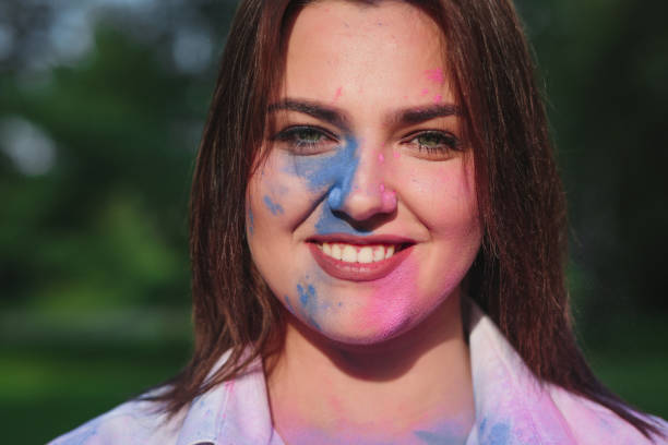 istock Happy brunette model with short hair covered Holi paint, posing in the park. Empty space 1329309057