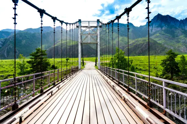 way to other side, old steel suspension bridge over mountain river