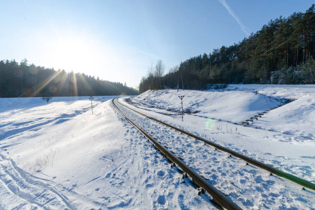 istock railway passing through the winter forest. sunny weather in winter. 1329311008