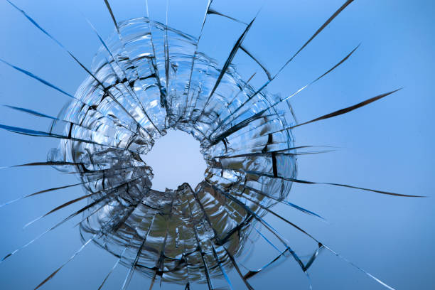 istock Cracks in the window glass on a background of sky. 1329311918