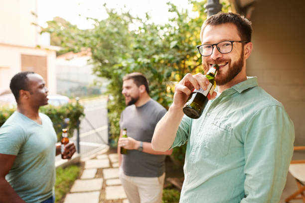 istock Smiling man drinking a beer outside with friends in the backyard 1329316791