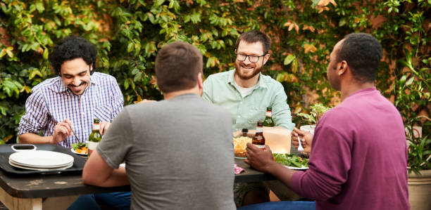 istock Male friends having dinner and beers in backyard 1329316925