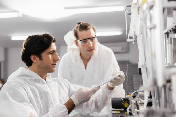 istock Technician or engineer working checking mask production machine at clean factory or laboratory, Face mask manufacturing production automation or quality concept 1329318929