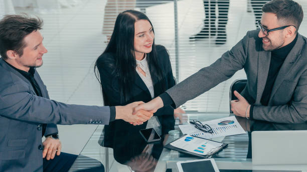 istock close up. business colleagues shaking hands over an office Desk 1329319085