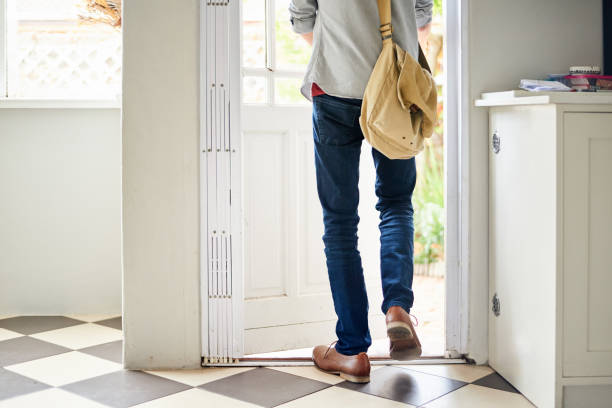 Young man walking outside through a door in his kitchen Rear view of an unrecognizable young man walking out through a door in his kitchen at home leaving stock pictures, royalty-free photos & images