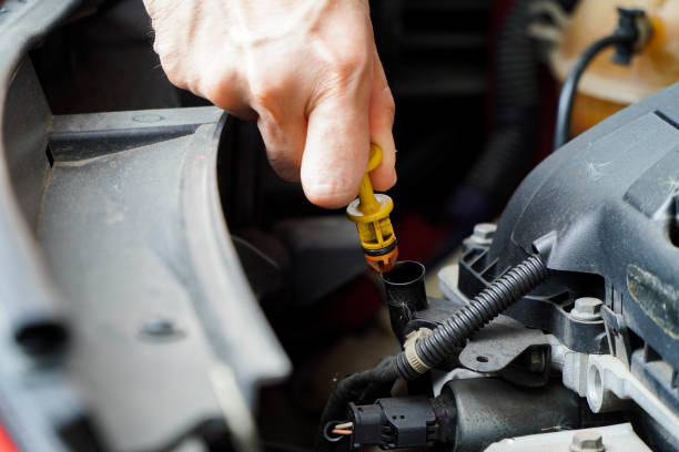 istock Auto mechanic checking the oil level in car engine,inspects engine water level dipstick 1329327159