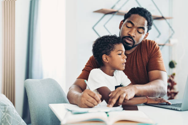 istock African-American ethnicity father working while his son use a laptop 1329328972