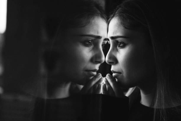istock unhappy woman crying at the window 1329331118