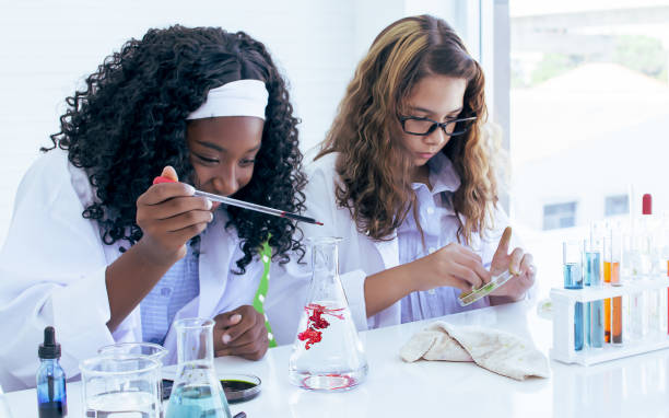 istock African black and caucasian girls studying science and making experiment in laboratory at school. Education and Diversity Concept. 1329331982