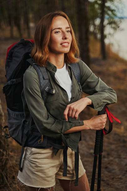 istock Beautiful lady leaning on walking poles in forest 1329331992