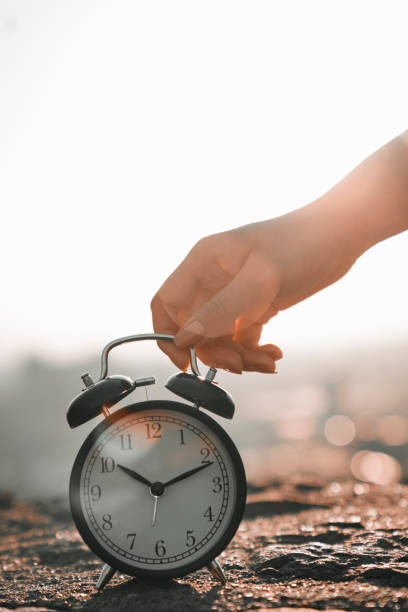 istock woman holding alarm clock, holiday time 1329333573