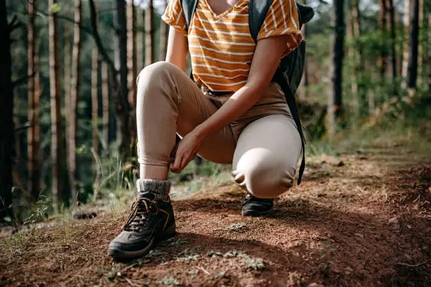 Female hiker tying the laces on her boots.