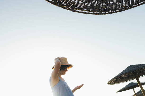 istock Happy Woman Relaxing on the Beach at Sunset (Copy Space) 1329334335