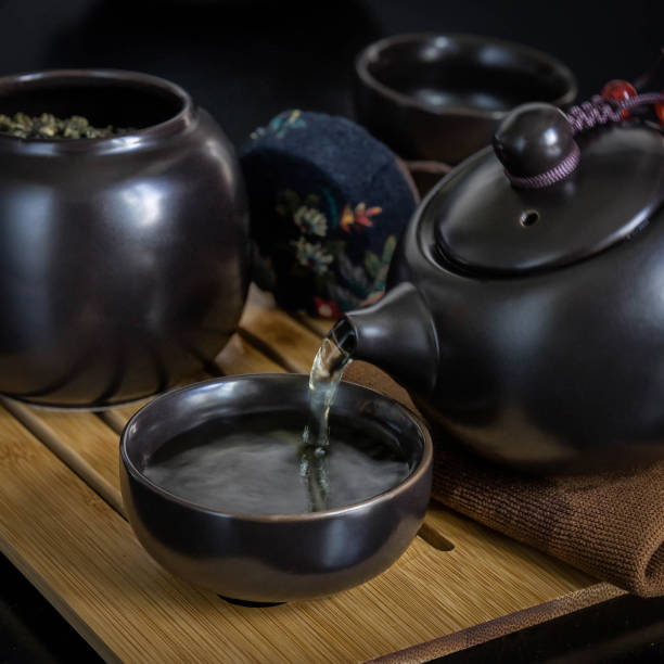 istock Pouring green tea into a black cup . 1329334458