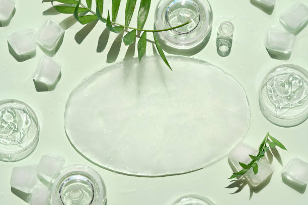 istock Ice mock-up, top view with copy-space. Self made moisturizer, oval piece of ice and small cubes. Exotic palm leaves on mint green background. Facial massage, handmade cosmetics 1329336491