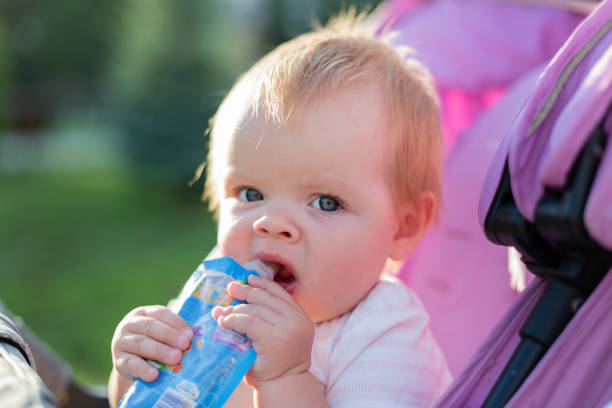 istock A small blonde child in a baby carriage eats mashed potatoes 1329336748