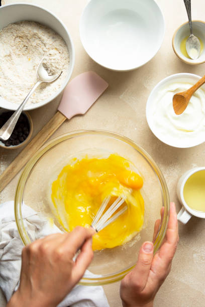 istock Female hands cooking a cake in glass bowl, top view. Mixing sugar and eggs, selective focus. Step by step recipe. 1329340796