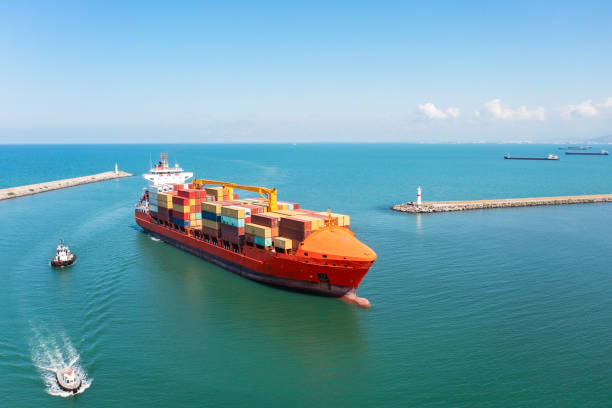 vista aérea do navio de contêineres de carga se aproximando do porto com rebocador. - container ship tugboat nautical vessel pulling - fotografias e filmes do acervo