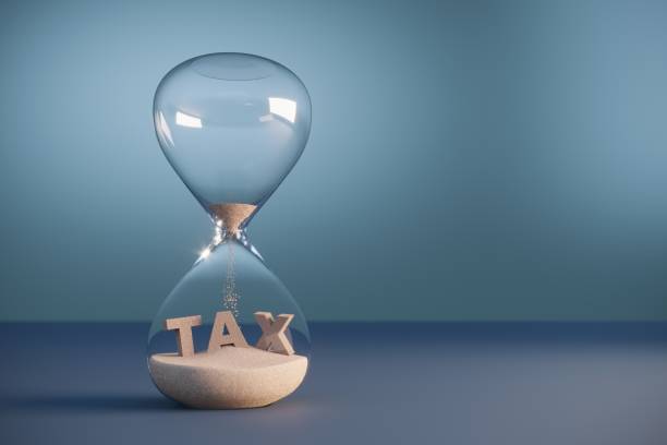 Tax Deadline Flowing sand shaped of tax text inside the hourglass. (3d render) income tax stock pictures, royalty-free photos & images