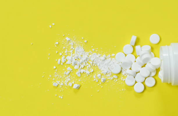 white tablet medicine mashed and  pouring from bottle on yellow background white tablet medicine mashed and  pouring from bottle arranging on yellow background crushed stock pictures, royalty-free photos & images