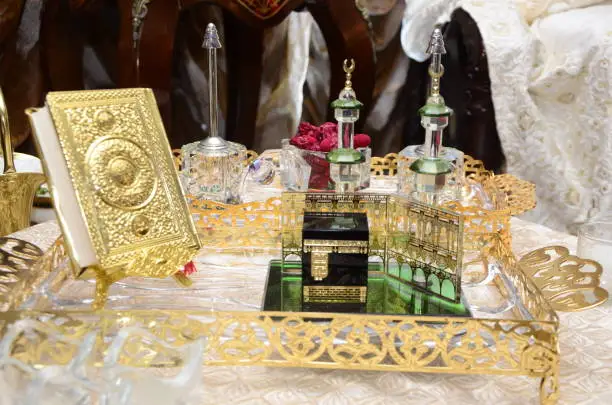 Holy Quran with golden cover. Small model of the city of Mecca